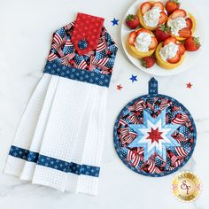 the patriotic table cloth is next to some strawberries and cupcakes