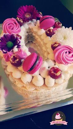 a cake decorated with flowers and marshmallows in the shape of the letter o