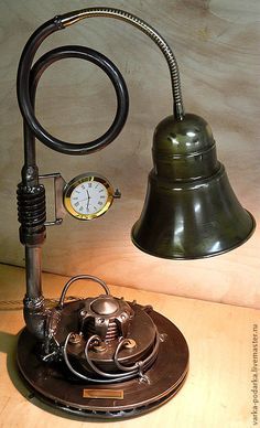 an old fashioned desk lamp with a clock on the side and a light bulb attached to it