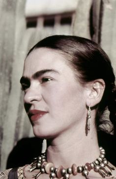 an old photo of a woman wearing necklaces and earring's on her neck