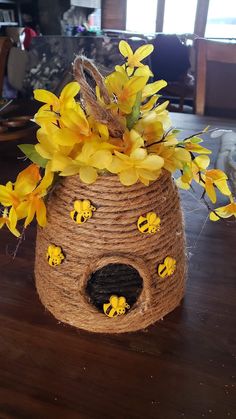 yellow flowers are growing out of the top of a burlocked birdhouse