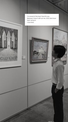 two people looking at pictures on display in an art gallery with white walls and black and white photography