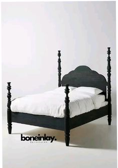 a black bed frame with white sheets and pillows