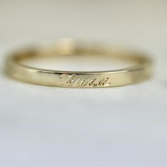 two gold wedding bands with the word love written on them