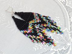 a pair of black beaded earrings with multicolored beads