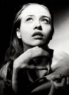 black and white photograph of a woman wearing a neck tie with her hands on her chest