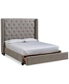 an upholstered bed with a pull out trundle and storage drawer underneath