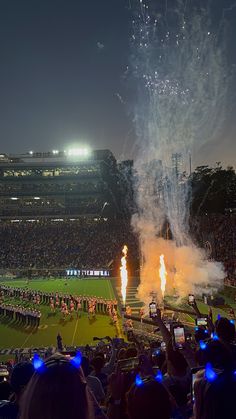 fireworks are lit up in the air at a football game