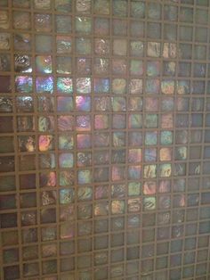 a tiled wall with different colored glass tiles on it's sides and the bottom