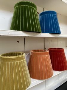 three different shades of lampshades are on the shelf in front of each other