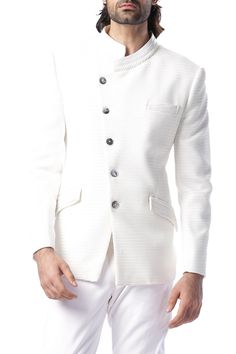 Cream textured cupro bandhgala jacket with asymmetrical placket and band collar. Comes with cotton slim fit trousers.
Component: 2
Neckline: Band Collar
Sleeve Length: Full
Fabric: Cotton, Textured Cupro
Color: White
Slant front button placket Pleated detailings on band collar and pockets Welt and flap front pockets - Aza Fashions Luxury White Bandhgala With Gota Work, White Bandhgala For Formal Winter Events, White Nehru Jacket With Stand Collar For Formal Occasions, Designer White Nehru Jacket For Semi-formal Occasions, White Classic Bandhgala For Semi-formal Occasions, White Nehru Jacket For Winter Formal Events, Classic White Bandhgala For Semi-formal Occasions, White Cotton Bandhgala For Festivals, Luxury Semi-stitched White Bandhgala