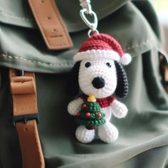 a crocheted dog with a christmas tree on it's back hanging from a backpack