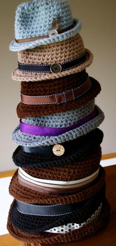 a stack of hats sitting on top of a wooden table