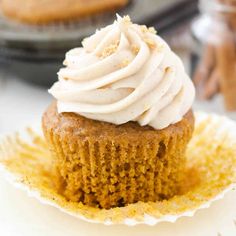 pumpkin cupcakes with cream cheese frosting on top and cinnamon cookies in the background