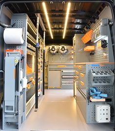 the inside of a van with shelves and tools on the wall, including cabinets and drawers