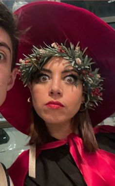 a man and woman in costume posing for the camera with their heads covered by flowers