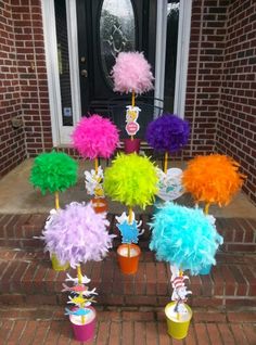 there are many colorful pom poms on the front steps and in vases