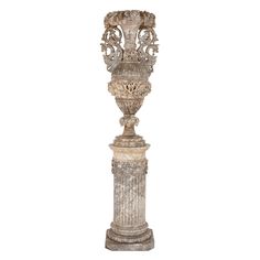 an ornate white marble urn with carvings on the top and sides, against a white background