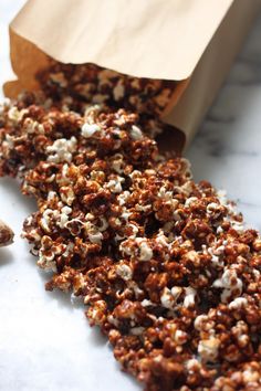 a bag full of popcorn sitting on top of a counter next to a piece of paper