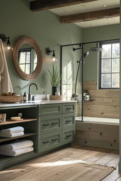 a bathroom with green walls and wooden floors, along with a large mirror on the wall