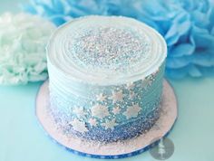 a cake with blue frosting and white sprinkles