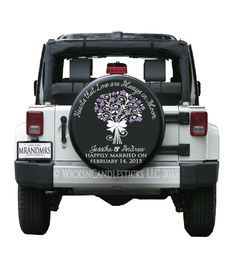 the back end of a white jeep with a tree on it's tire cover