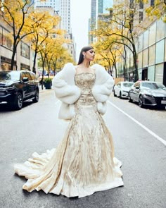 a woman in a dress and fur coat on the street