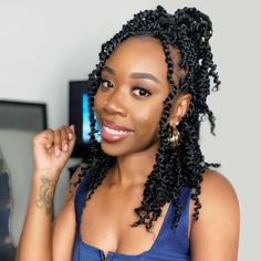 a woman with large braids smiling at the camera