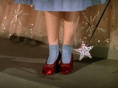 a close up of a person's red shoes with a star on the floor