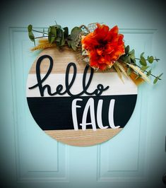 a wooden sign that says hello fall hanging on a door with an orange flower in it