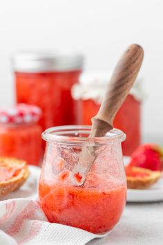 a jar filled with liquid sitting on top of a table next to sliced oranges