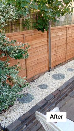 a wooden fence next to a white lawn chair and some plants on the side of it