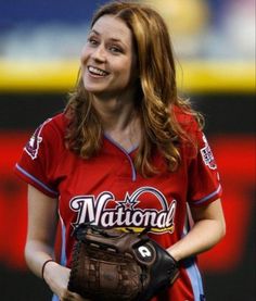 a woman wearing a catchers mitt and smiling