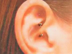 a woman's ear is shown with two small diamonds