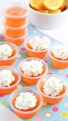 orange cupcakes with white frosting in plastic cups