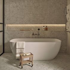 a white bath tub sitting next to a wooden stool