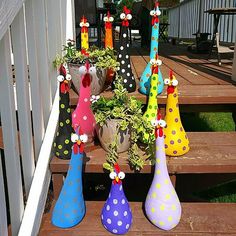 several colorful vases are sitting on the steps in front of some plants and potted plants