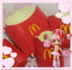 there is a doll that is standing next to mcdonald's pillows and bags with hearts on them