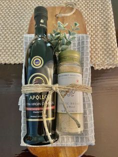 a bottle of wine and some spices in a wooden box on a table with a cloth