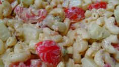 pasta salad with tomatoes and onions in a bowl