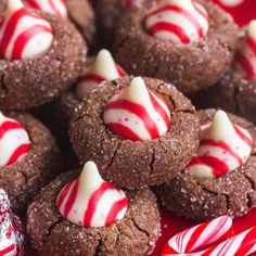 chocolate cookies with white and red candy canes in the middle on a red plate