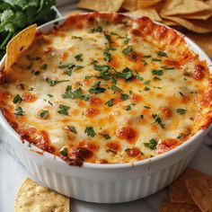 a cheesy dish with tortilla chips on the side