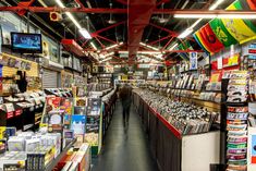 a store filled with lots of different types of items and people walking through the aisles