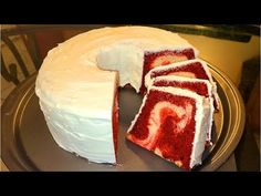 a red velvet cake with white frosting and swirls on the top is cut in half