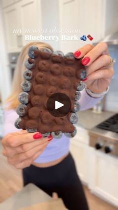 a woman holding up an object made out of chocolate