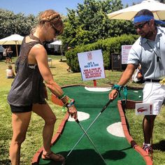 two people playing mini golf in the grass