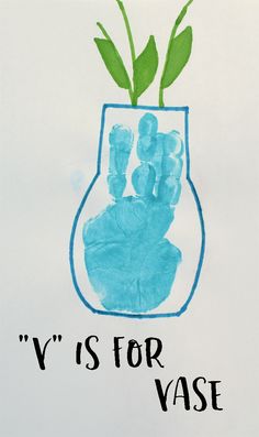 a child's handprint in the shape of a vase with green plants inside