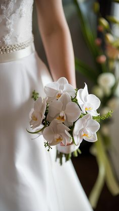 a bride holding a bouquet of white flowers