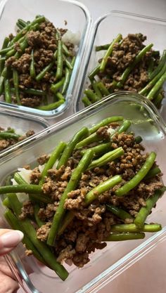 three plastic containers filled with green beans covered in ground meat and onions, sitting on a table