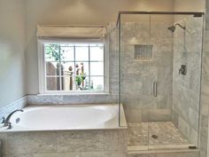 a bathroom with a tub, shower and window